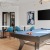 a room with a pool table and chairs